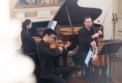 A violinist, cellist, and pianist perform.
